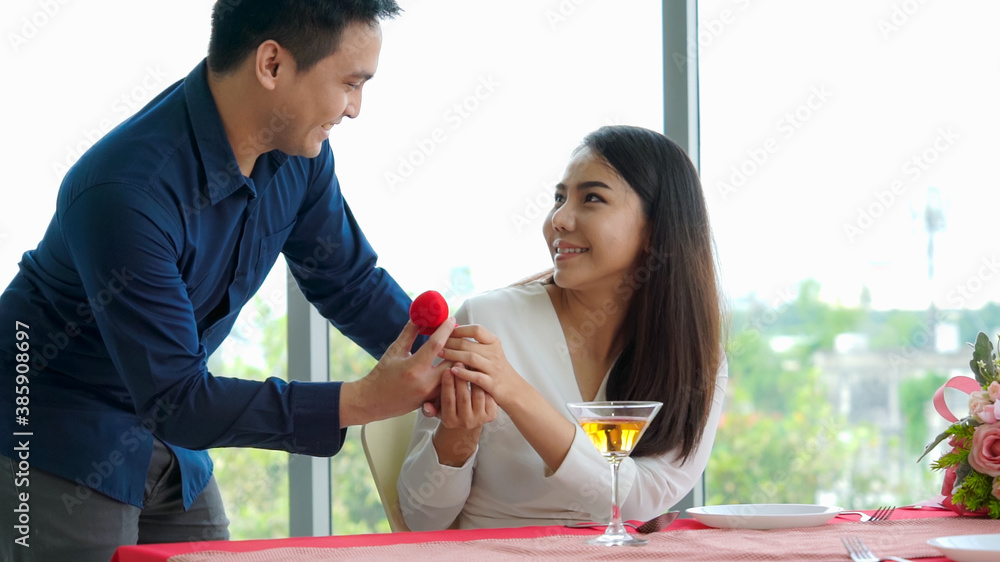 Romantic couple giving gift to lover at restaurant . Happy couple lifestyle .