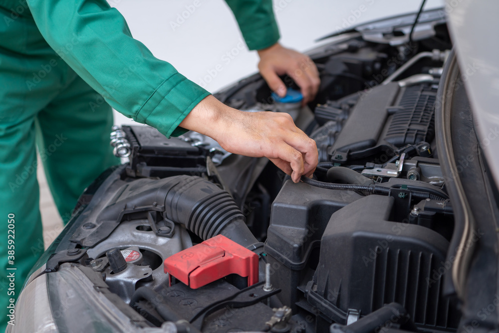 Professional mechanic hand providing car repair and maintenance service in auto garage. Car service 