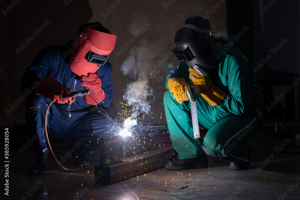 Metal welding steel works using electric arc welding machine to weld steel at factory. Metalwork man