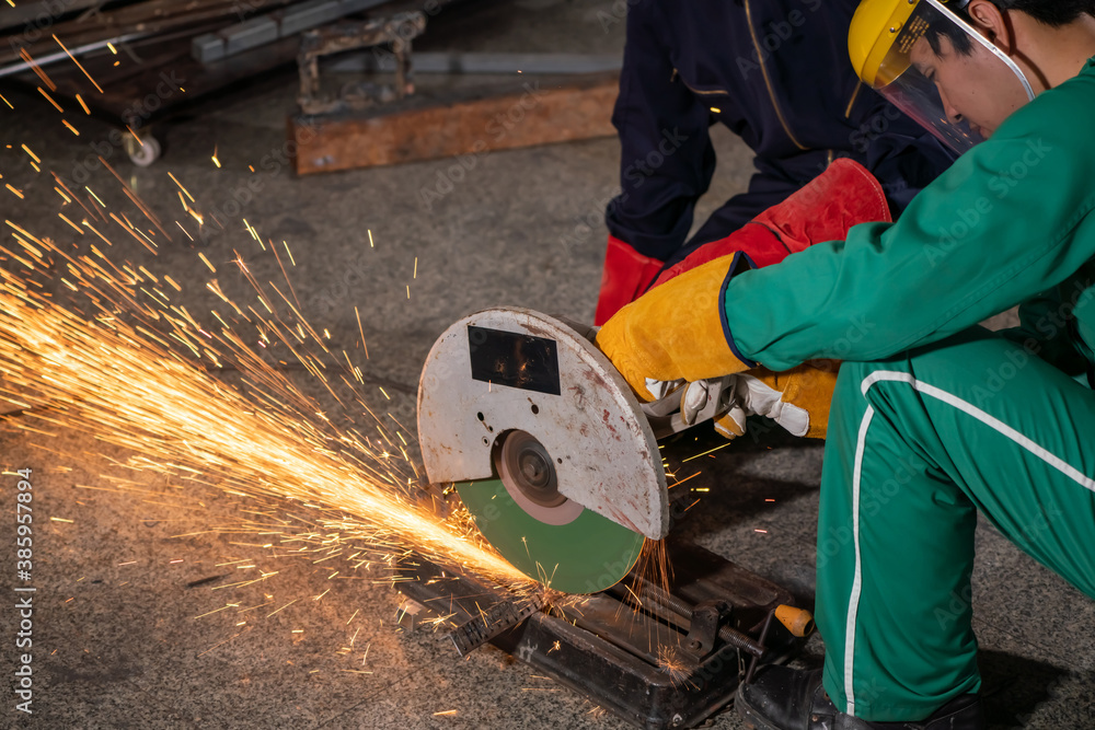 Professional mechanic man is cutting steel metal with rotating carbon blade cutter. Steel industry a