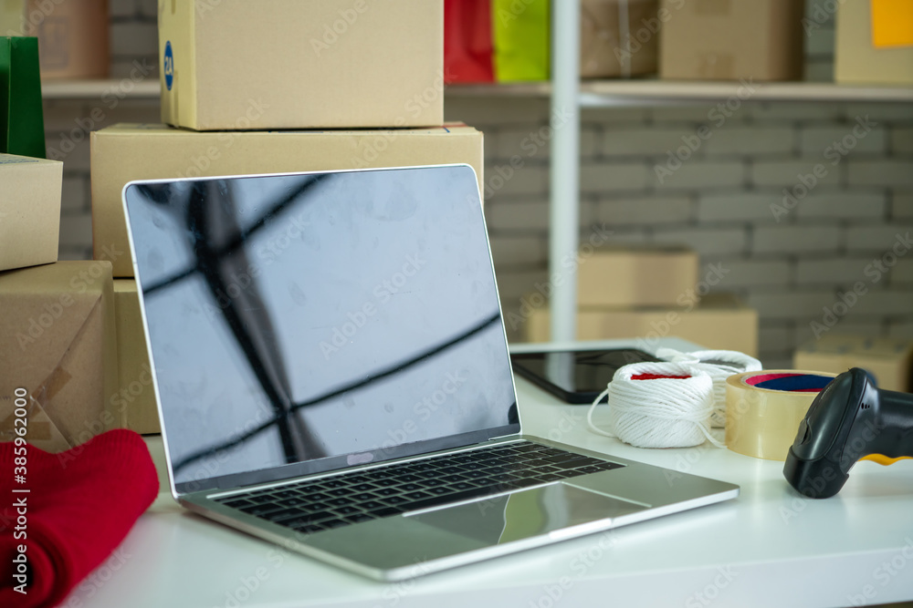 Laptop computer with empty screen on shipping box background. Concept of online retail store, delive