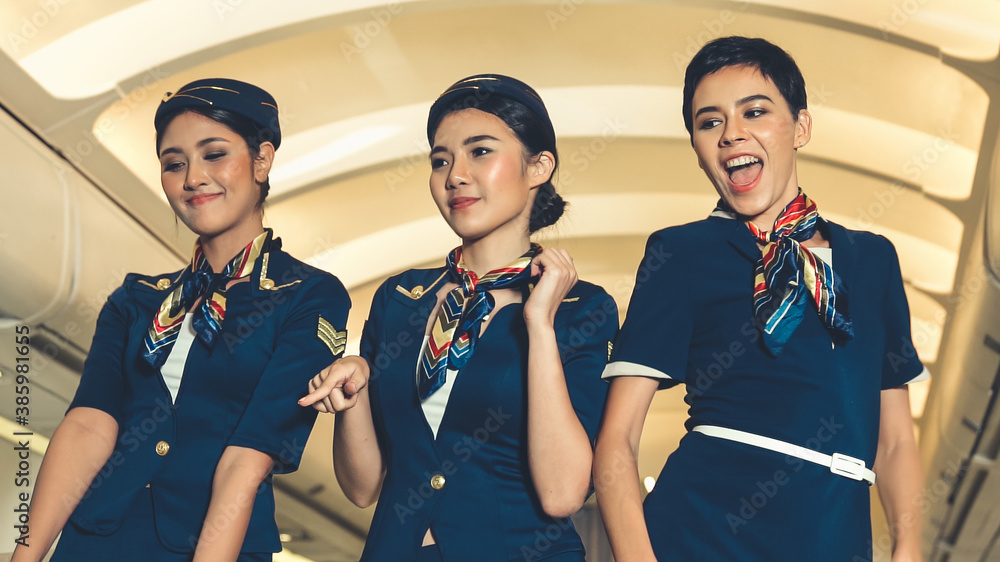 Cabin crew dancing with joy in airplane . Airline transportation and tourism concept.