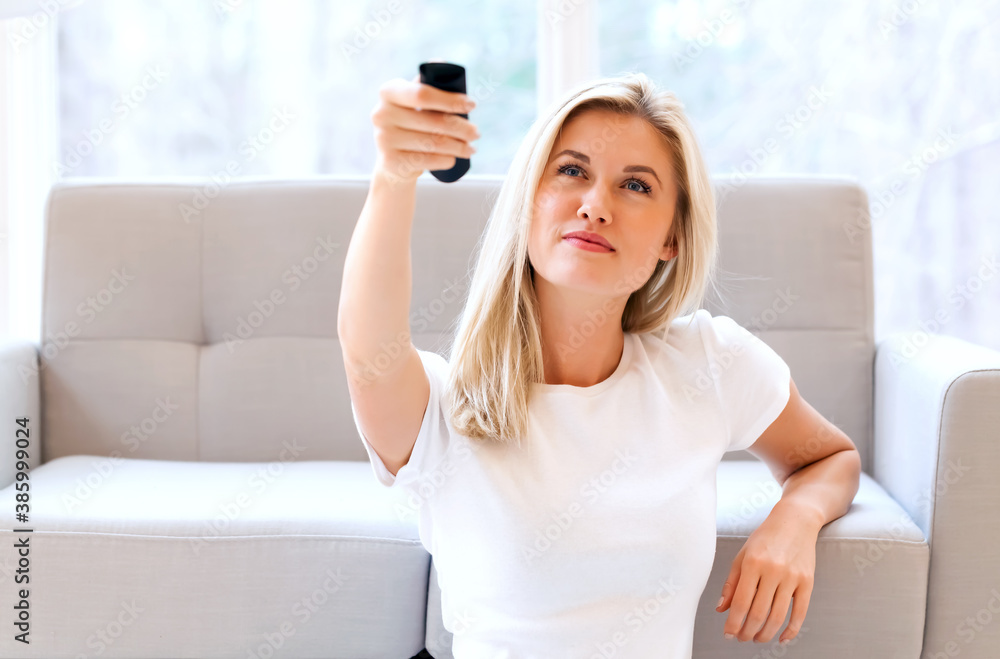 Young woman watching TV in her living room