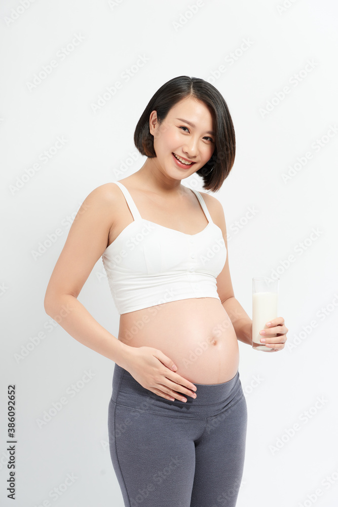 Pregnant woman drinking milk on the white background.