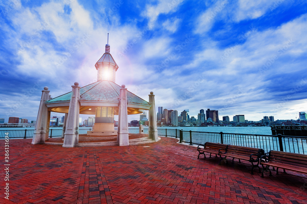 East Boston Piers Park Gazebo with lighthouse light in the evening over downtown panorama view