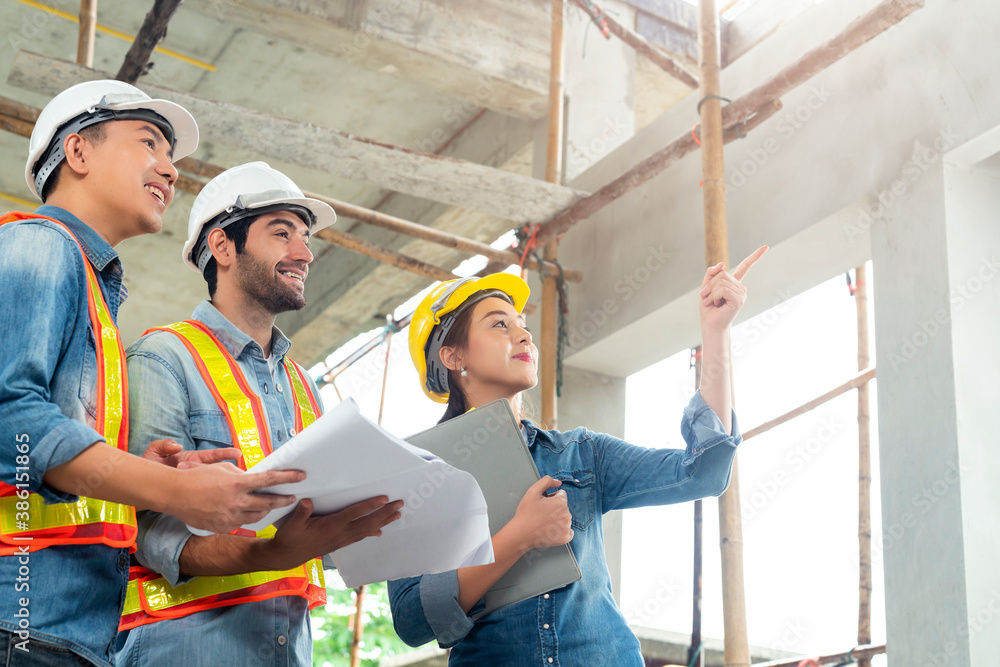 Young Asian engineers and caucasian engineer colleagues at site inspector and discuss together using