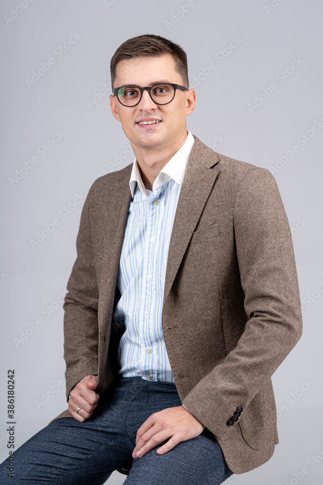 Young businessman portrait. Professional accountant or bookkeeper is looking to the camera. Light gr