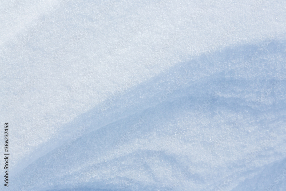 Beautiful winter background with snowy ground. Natural snow texture. Wind sculpted patterns on snow 