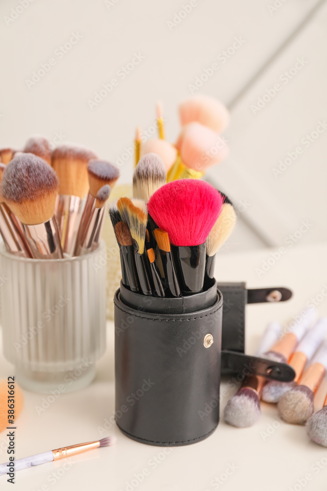 Set of makeup brushes on table