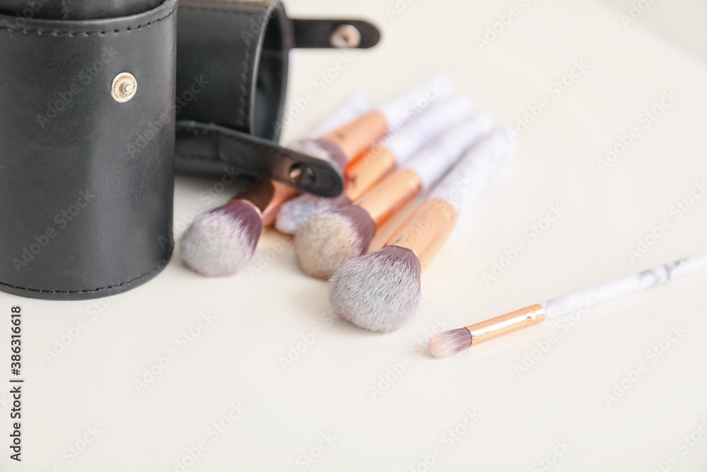 Set of makeup brushes on table