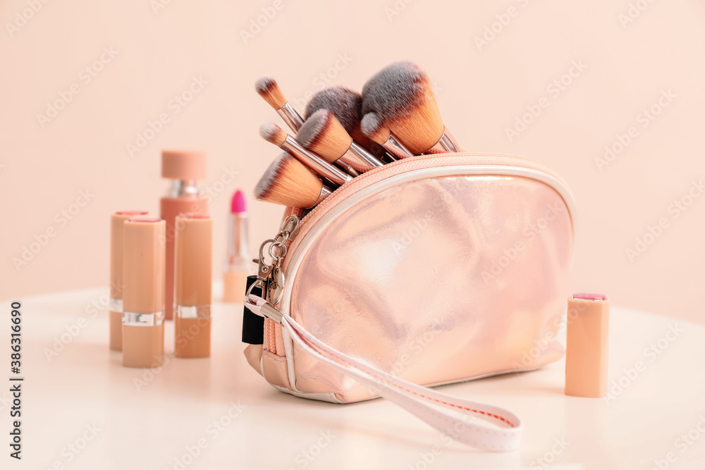 Set of makeup brushes with decorative cosmetics on table