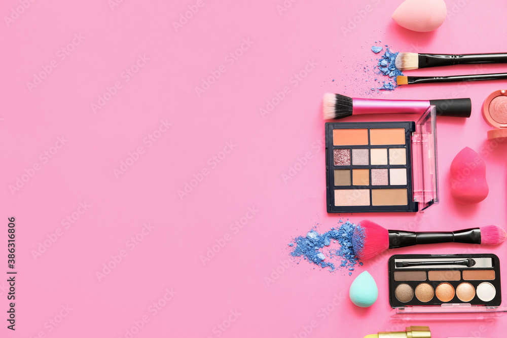 Set of makeup brushes with decorative cosmetics on color background