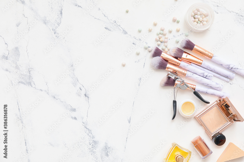 Set of makeup brushes with cosmetics on white background