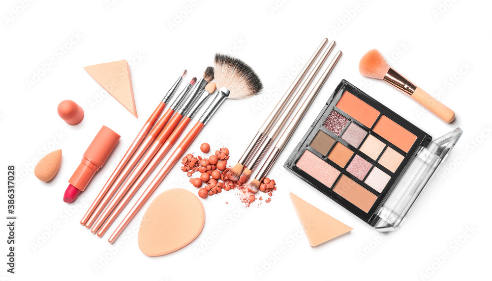 Set of makeup brushes with decorative cosmetics and sponges on white background