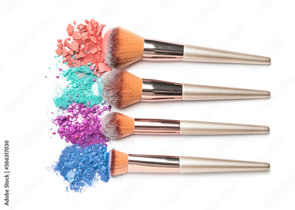 Set of makeup brushes with decorative cosmetics on white background