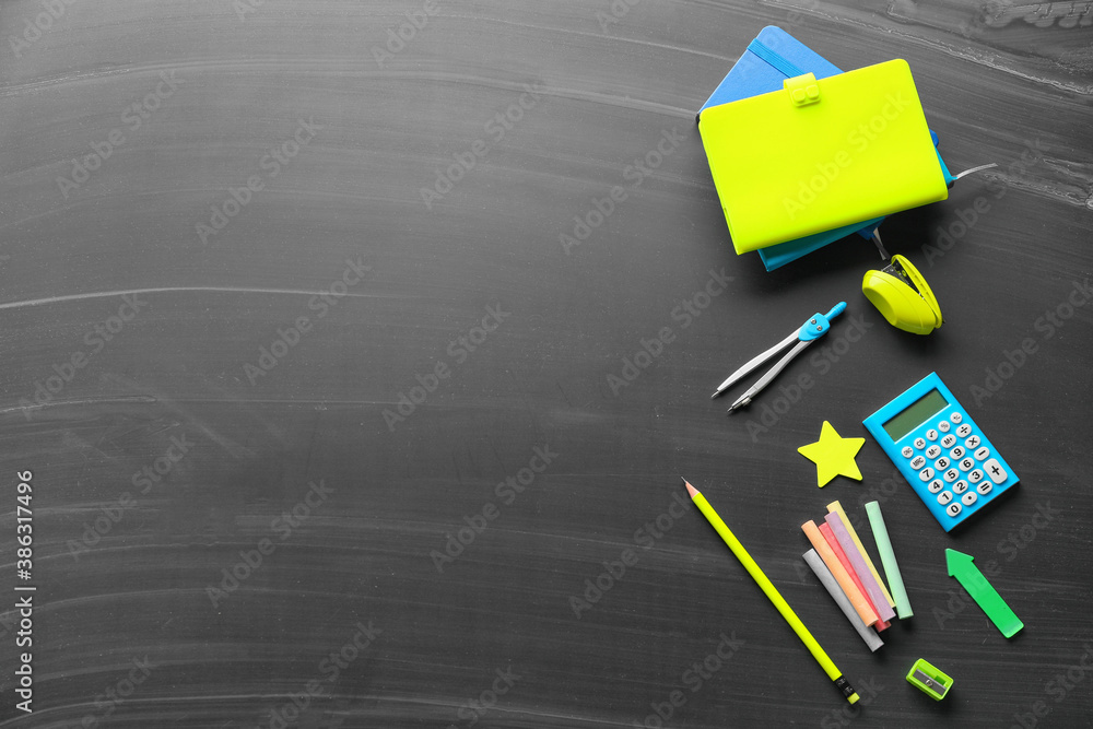 Set of school stationery on blackboard