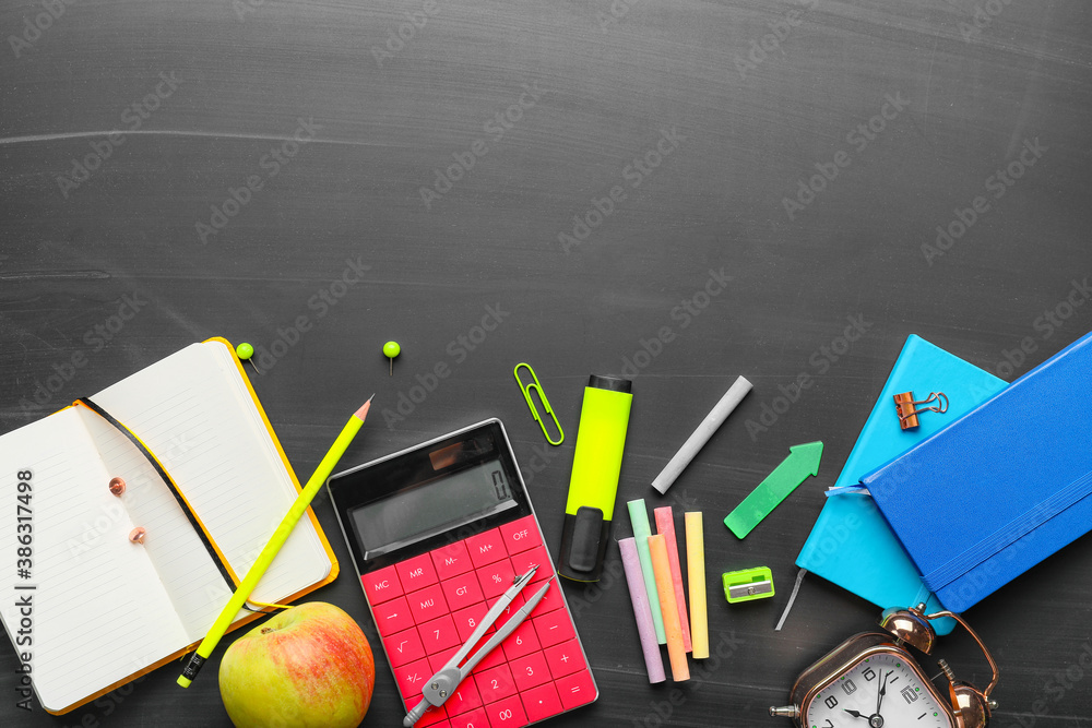 Set of school stationery on blackboard