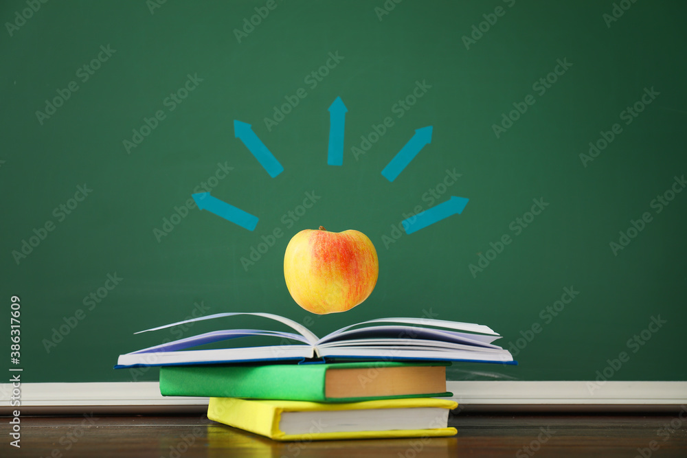 Creative composition with books and apple in classroom