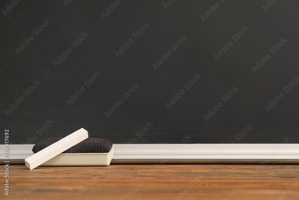 Piece of chalk with sponge on table in classroom