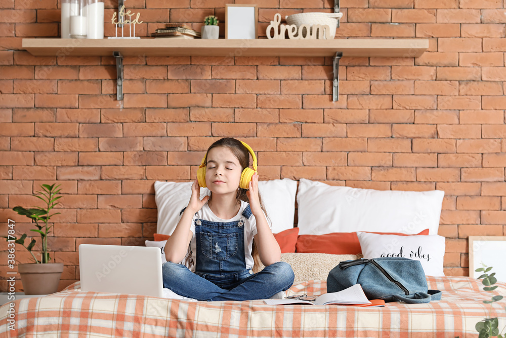 Cute little girl listening to music at home