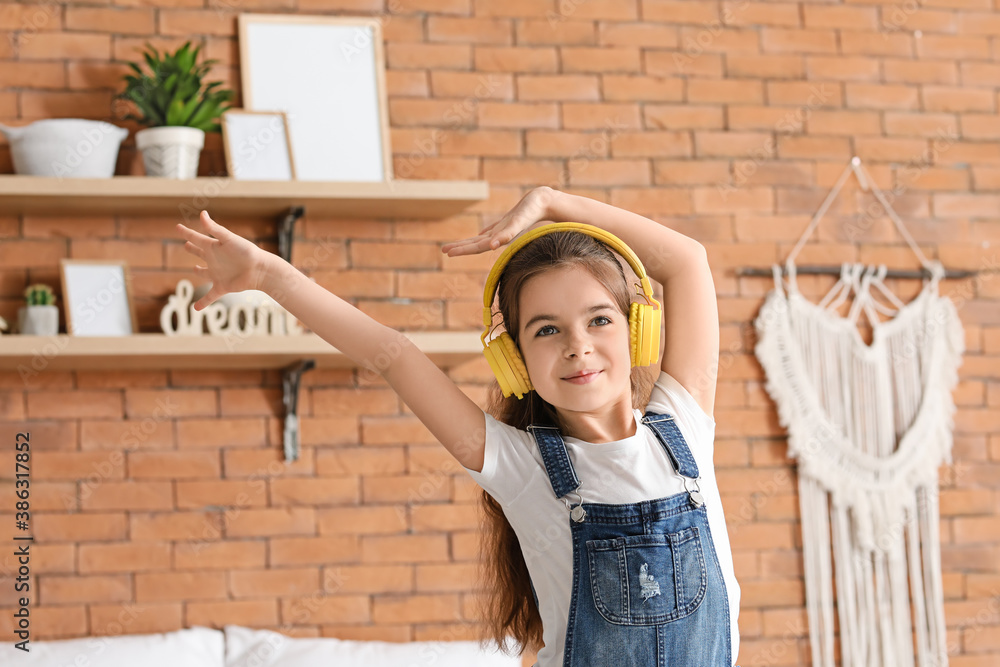 Cute little girl listening to music at home