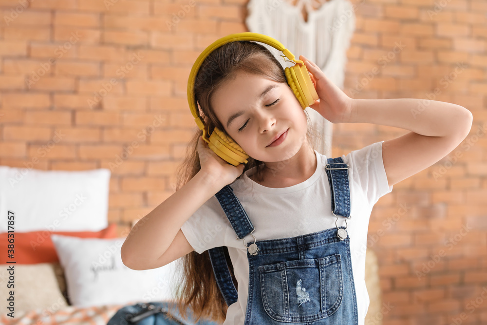 Cute little girl listening to music at home