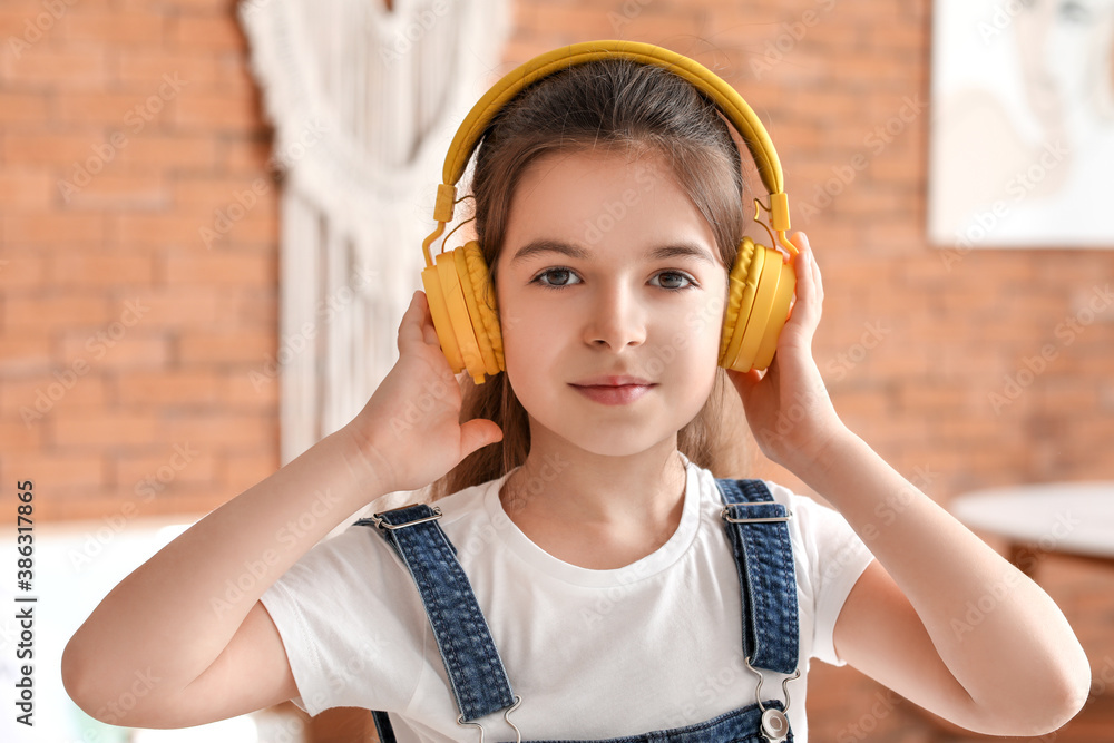 Cute little girl listening to music at home