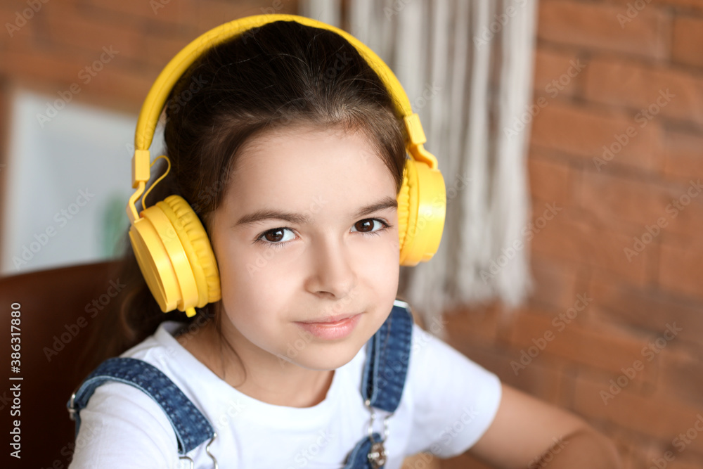 Cute little girl listening to music at home