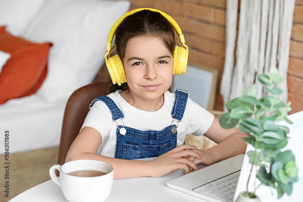 Cute little girl listening to music at home