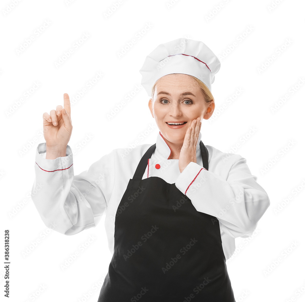 Surprised female chef pointing at something on white background