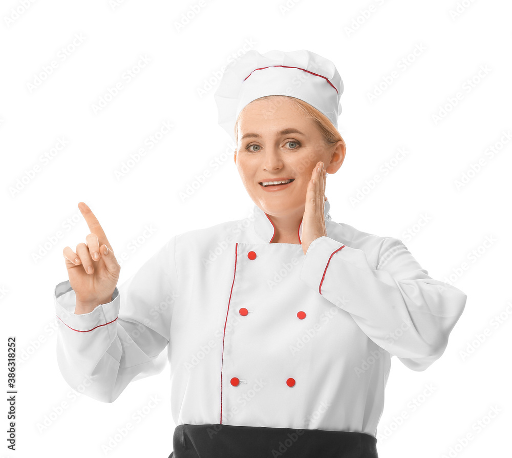 Mature female chef pointing at something on white background