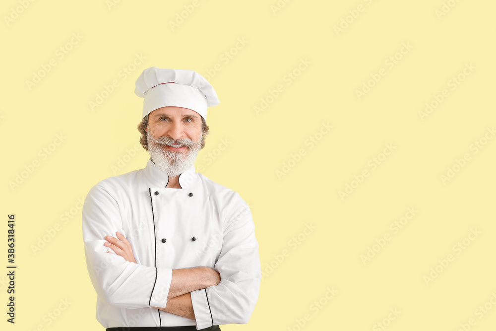 Mature male chef on color background