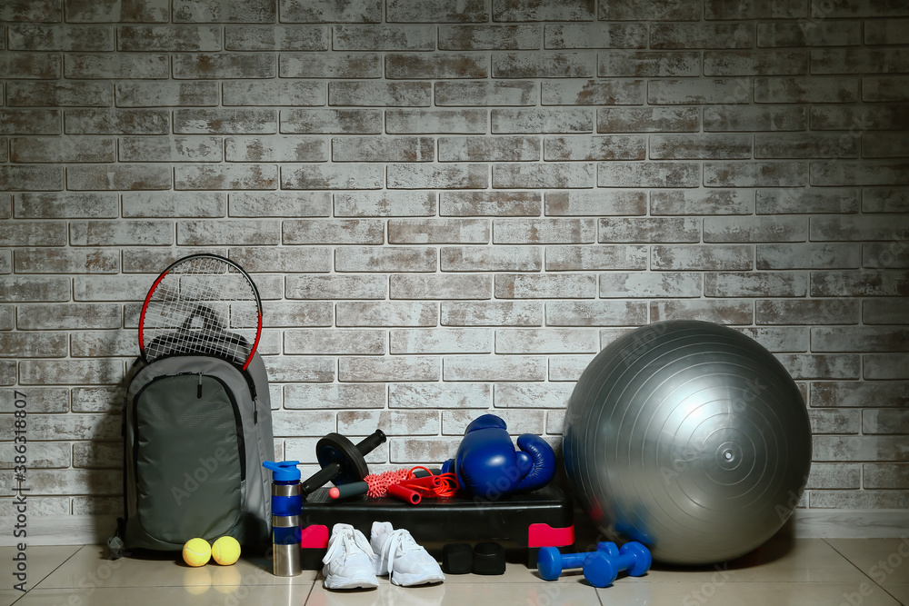 Set of sport equipment on floor near brick wall