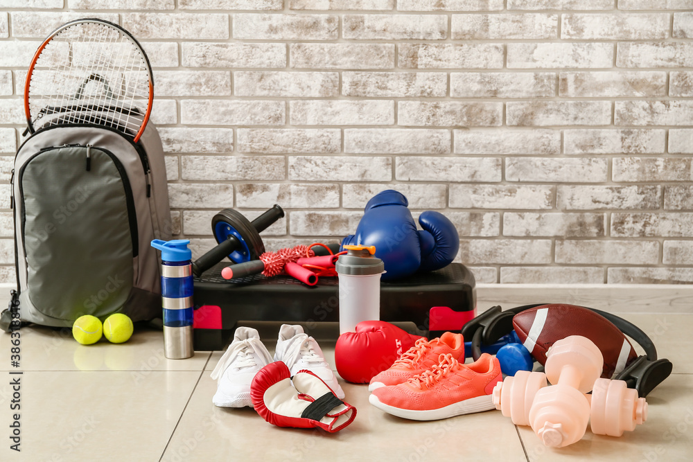 Set of sport equipment on floor near brick wall