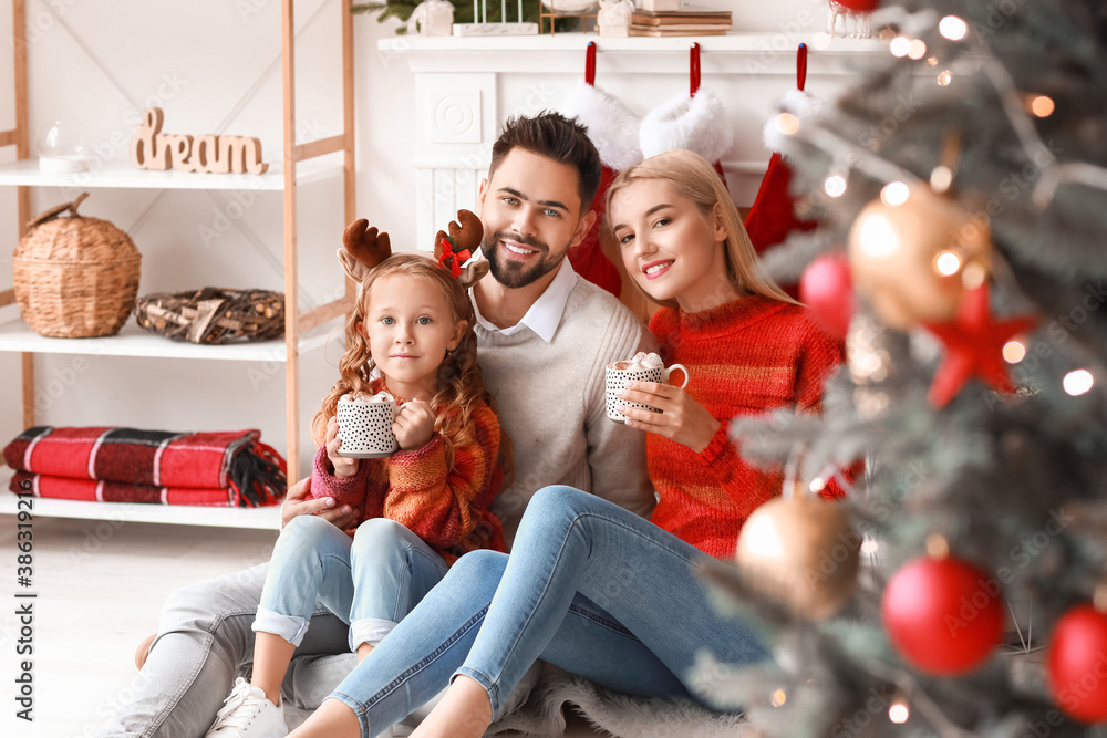 Young family drinking cacao drink at home on Christmas eve