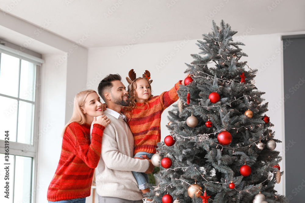 Young family decorating Christmas tree at home