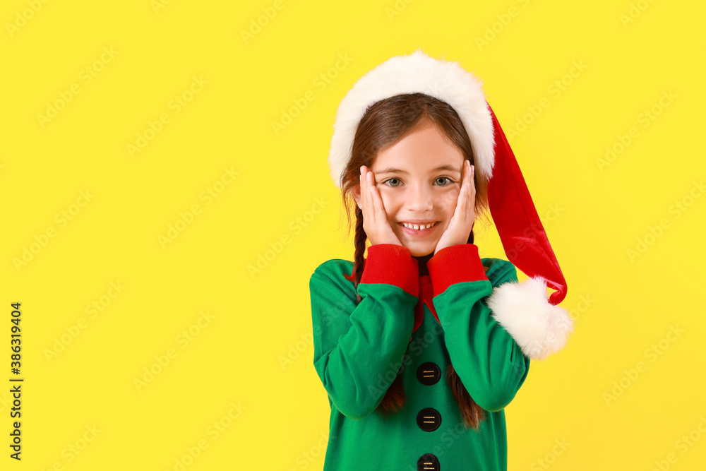 Cute little girl dressed as elf on color background