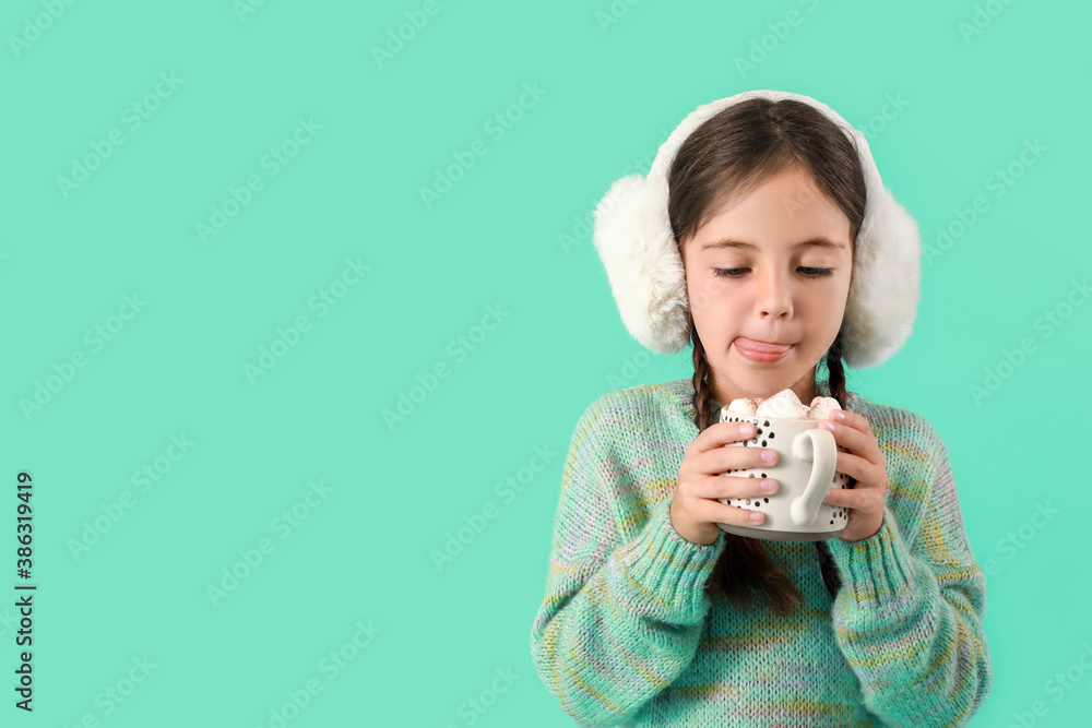 Cute little girl with cup of hot chocolate on color background