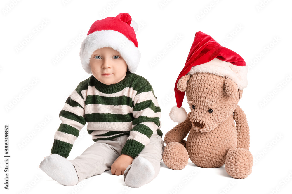 Cute little baby in Santa hat and with toy on white background