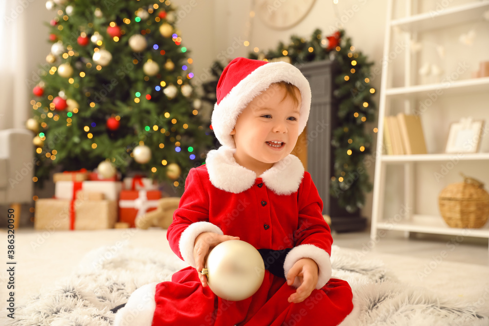 Cute little baby in Santa costume at home on Christmas eve