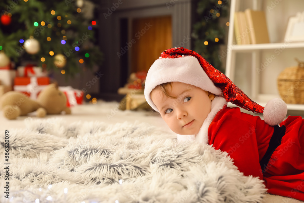 Cute little baby in Santa costume at home on Christmas eve