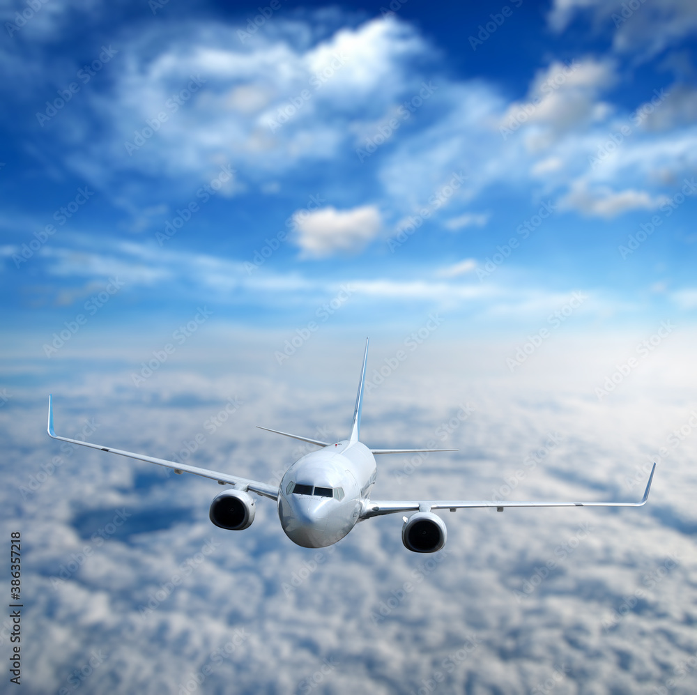 White airplane flying above clouds in the sky