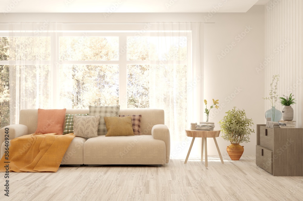 Stylish room in white color with sofa and autumn landscape in window. Scandinavian interior design. 