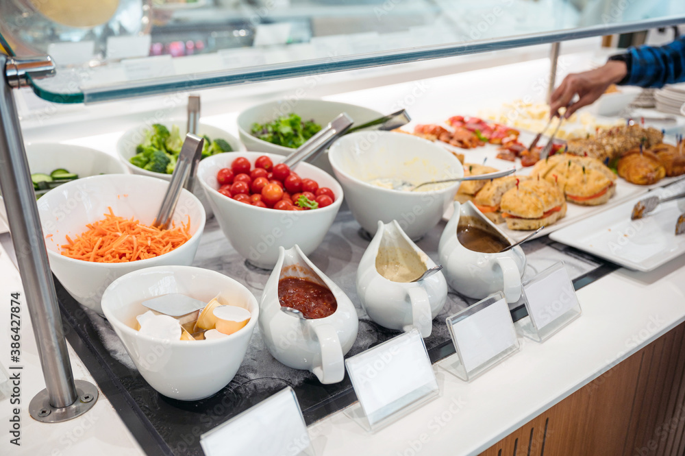 Salad bar with variety sauce, topping vegetables and bread on the buffet table