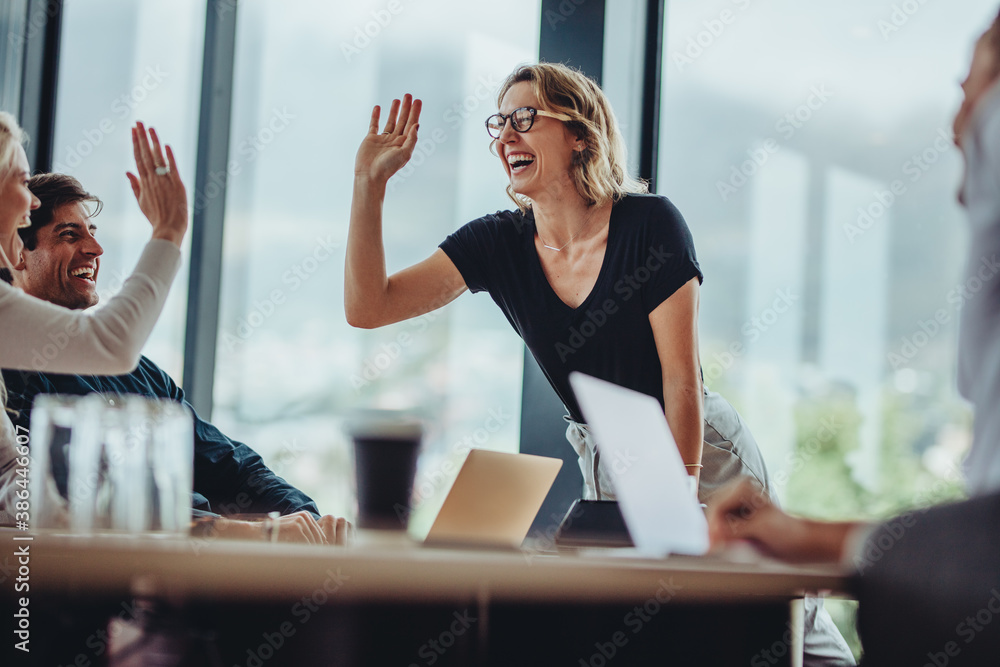 Business people high five in a meeting