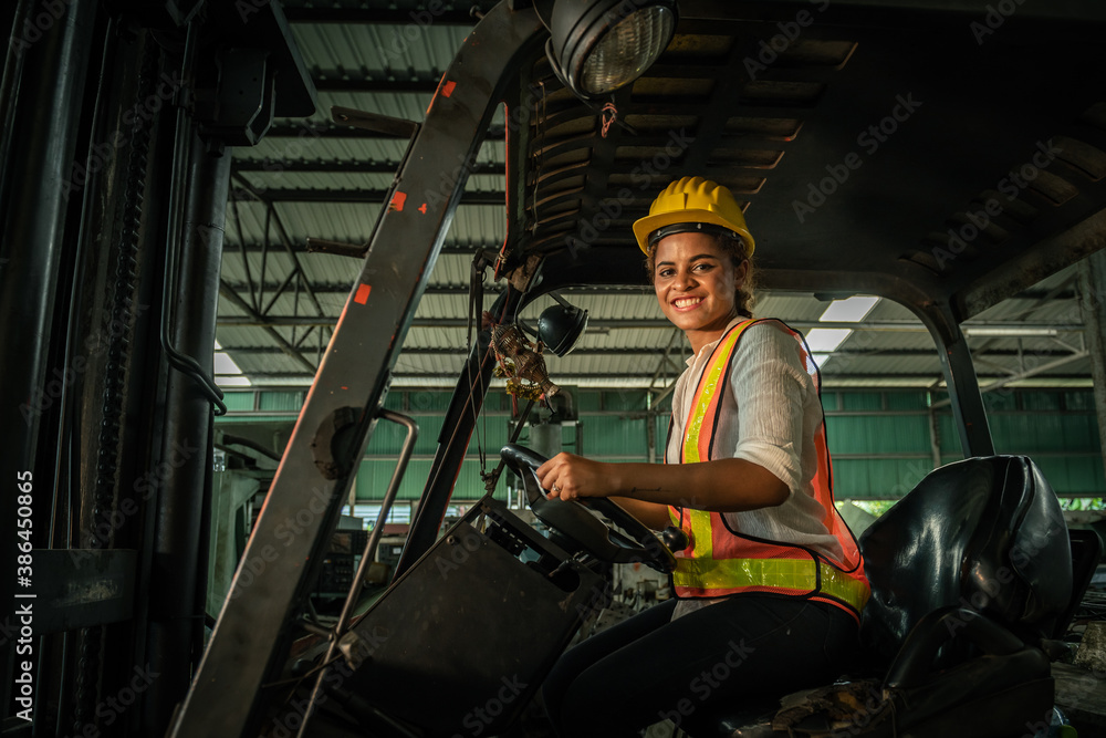 Female engineers are working on industrial machines. And wear a helmet for safety while working. Con