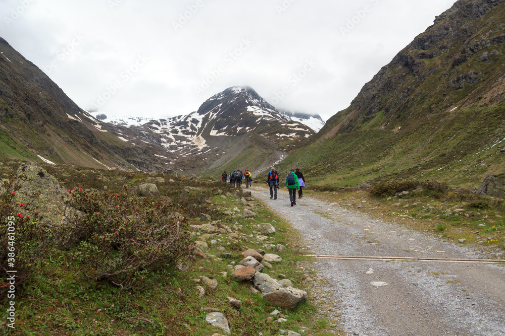 Group of people hiking and mountain snow panorama in Tyrol Alps, Austria