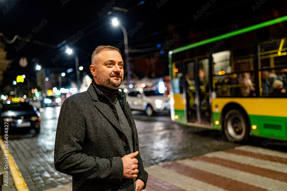 Handsome fashion mature male model. Outdoor portrait of an adult man in coat.