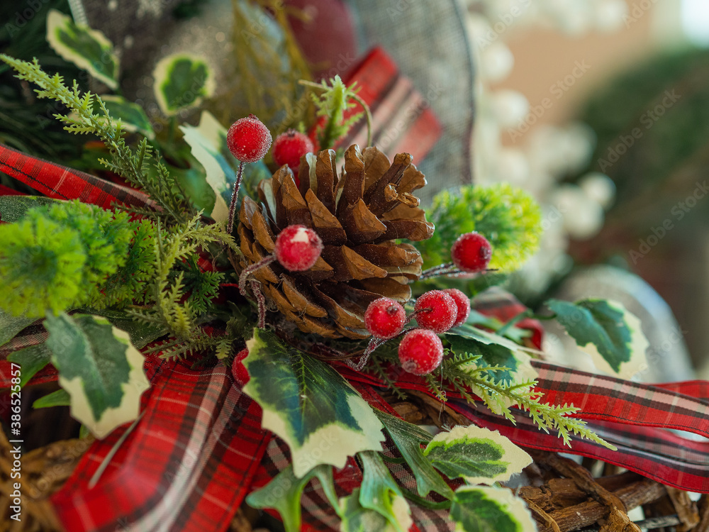 Pine cone on the Christmas tree with some berrys around it and a red bow