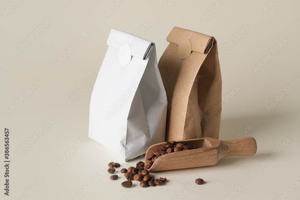 Blank coffee bags and scoop on light background